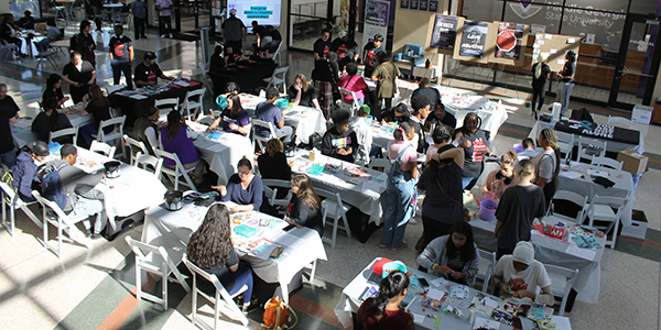 Image of a large room full of students sitting at tables doing an activity.